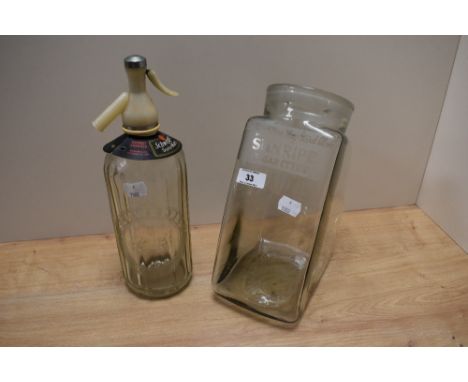 A vintage advertising jar 'For Size of Some, They Stand Alone, Sunripe Cigarettes' and a Scweppes Soda water siphon.