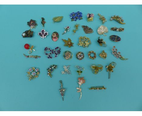 A collection of flower and foliate design brooches to include ceramic crown china, enamel etc