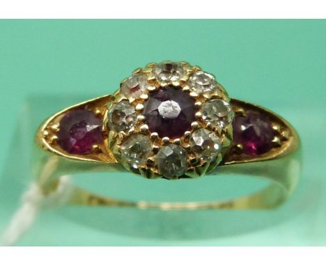 An 18ct gold ring set with three round cut rubies and old cut diamonds, Birmingham 1906 (size K)