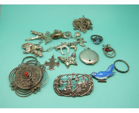 A collection of silver jewellery to include an enamel brooch, silver brooches, silver charm bracelet etc
