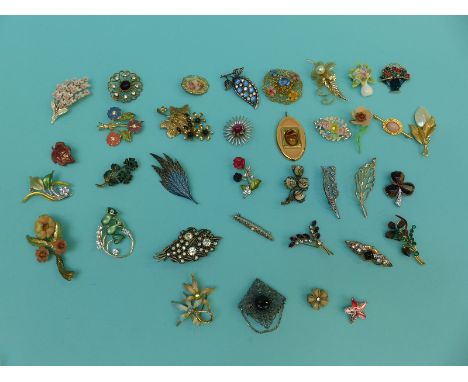 A collection of brooches of largely floral design to include a banded agate 'miracle' example, Channel Islands ceramic etc
