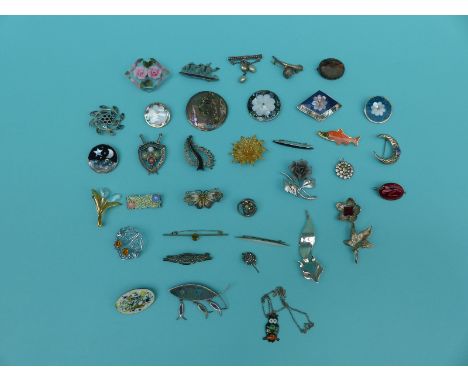 A collection of silver brooches to include abalone, filigree, enamel and a lucite example 