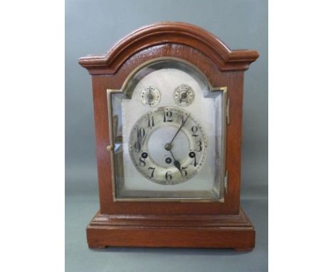A three train Junghans mantel clock with silvered Arabic dial, striking on a gong with strike silent facility