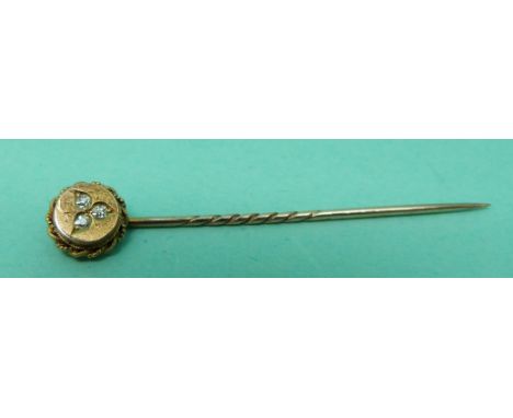 A 15ct gold stick pin set with three diamonds