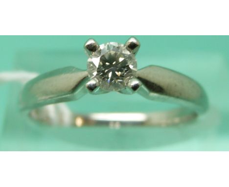 A platinum ring set with a round brilliant cut diamond (size M)