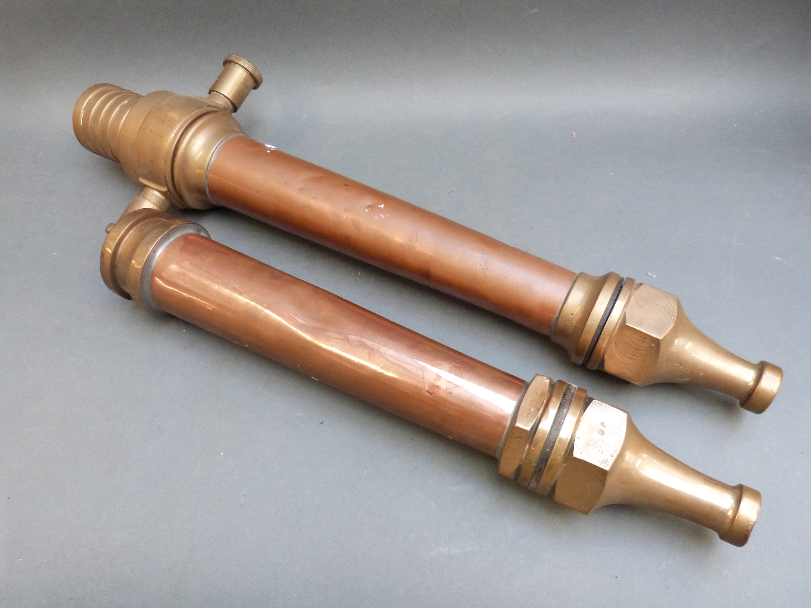Two vintage copper and brass fire hose nozzles