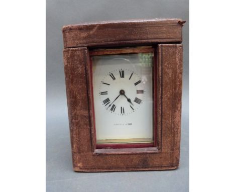 A Mappin & Webb cased brass carriage clock with reeded columns, enamelled Roman dial and blued steel hands, complete with car