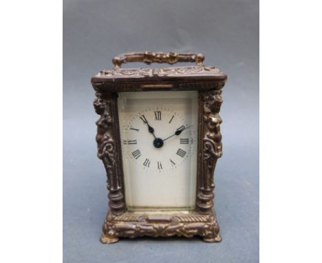 Brass carriage clock of small proportions, the columns decorated with semi-clad female forms, the Roman dial with blued steel