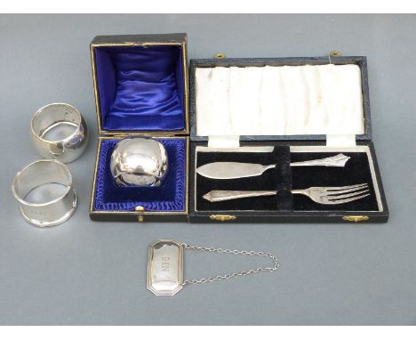 Three various hallmarked silver napkin rings including a cased example, a modern hallmarked silver gin bottle ticket or label