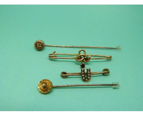 Two Victorian stick pins one set with a diamond, a 9ct gold brooch set with a ruby and a Victorian brooch in the form of a U 