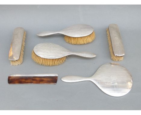 A hallmarked silver dressing table set comprising mirror, four brushes and a comb