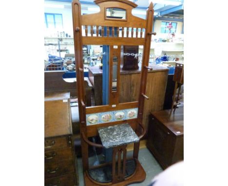 An Arts and Crafts style tile backed coat and stick stand with drip tray, height 190cm