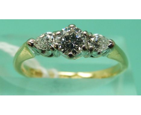 An 18ct gold ring set with a modern round brilliant cut diamond measuring approximately 0.3ct, and two pear mixed cut diamond