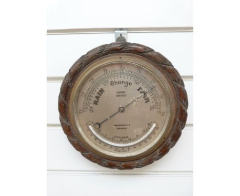 A John Barker Kensington oak rope twist barometer with curved thermometer below, marine aneroid to dial, diameter 23cm 