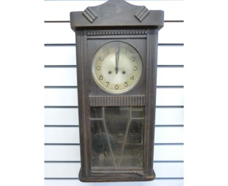 A c1930 Art Deco oak cased wall clock, the silvered dial with Arabic numerals and stylized hands, the two train movement by J