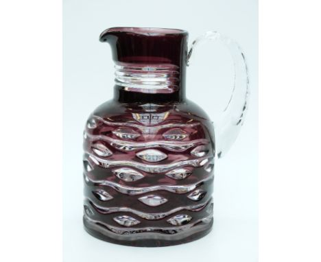 An amethyst flash overlaid glass water jug with cut decoration and applied handle, 21cm tall