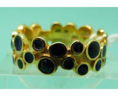 An 18ct gold ring set with circles of blue enamel (size Q), weight 5.96g