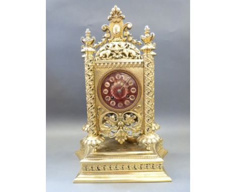 A highly ornate French mantel clock in gilt brass pierced case supported on spiralled floral and foliate columns, the top sur