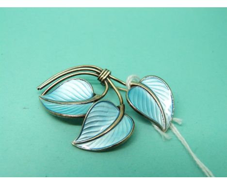 A silver brooch in the form of three leaves set with blue enamel and marked Norway 