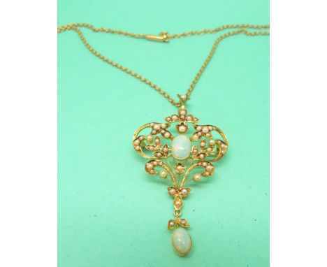 An Edwardian 15ct gold pendant set with seed pearls and two opal cabochons on a 15ct gold chain, in original box 