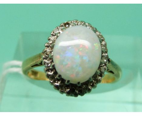 An 18ct gold ring set with an opal cabochon surrounded by diamonds (size J)