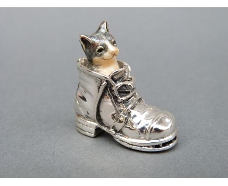 An enamel cat emerging from a hallmarked silver boot, height 3.5cm