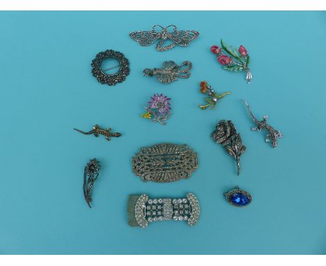 A collection of marcasite brooches including an enamel and marcasite flower and a silver example