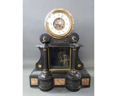 A late 19thC two train slate mantel clock in drum style case, with marbled inset decoration and carved cherubs to base, the t