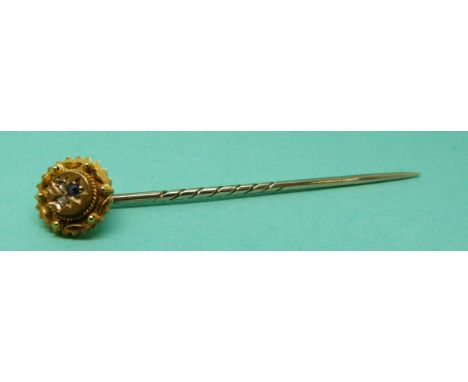 A 15ct gold stick pin set with a sapphire and two diamonds