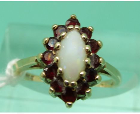 A 9ct gold ring set with an opal cabochon surrounded by garnets (size H)