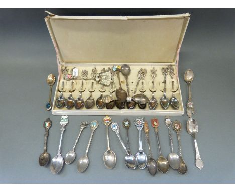 A collection of white metal and plated collectors' spoons, some with enamel crests