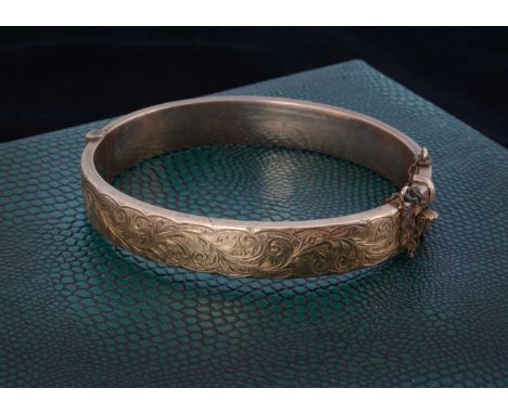 A 9ct gold bangle, with engraved design, 5.7cm x 5.4cm, 11.6gThis lot is in nice condition, clasp is in good working order th