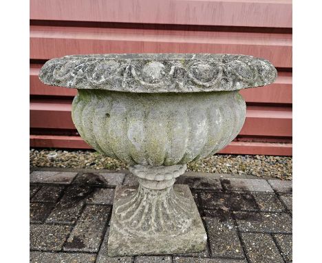 A reconstituted weathered stone urn garden planter, standing at 52cm tall, good condition with usual signs of wear