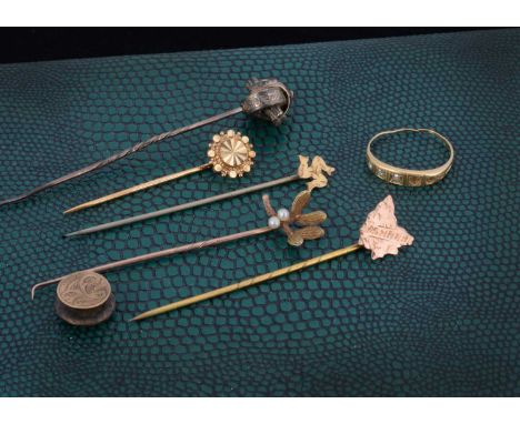 A collection of gold stick pins, one in the form of Tazmania stamped Tazmania, another with mistletoe, Isle of Man (base meta