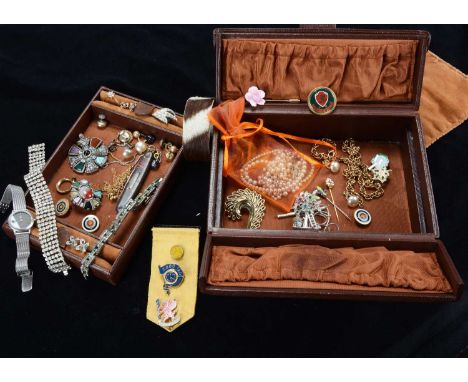 An early 20th Century leather jewellery box, with central opening compartment containing various costume jewels, including pa