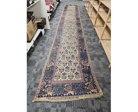 A large vintage woollen runner carpet, As Found, 613cm by 100cm, misshapen, one notable hole, other damages and wear and in n