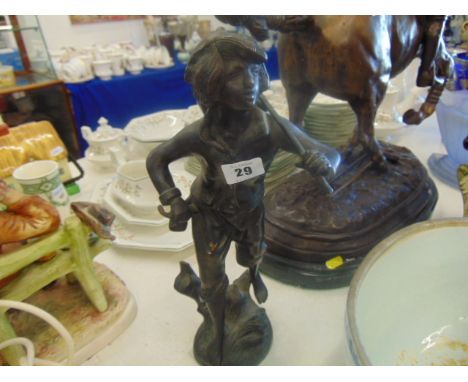 A bronze figure of a boy carrying a basket
