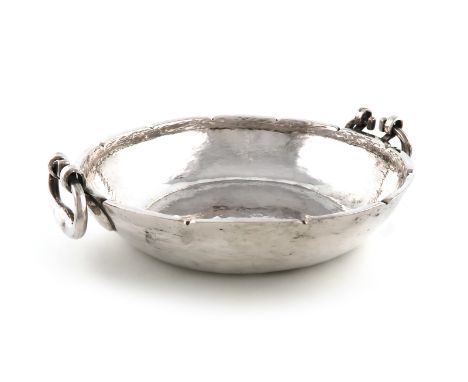 A South American metalware silver two-handled bowl, unmarked, shallow circular form, spot-hammered decoration, drop ring hand