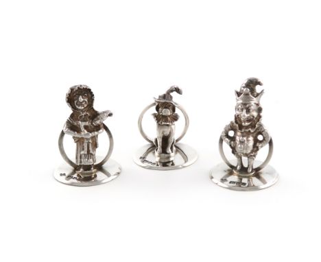 A set of three novelty silver menu card holders, by Horace Woodward and Co., London 1910, modelled as Mr Punch, Judy and Toby