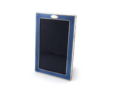 A silver and blue enamel photograph frame, by Samuel Levi, Birmingham 1931, upright rectangular form, the blue enamel on an e