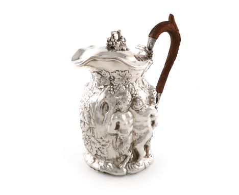 An Edwardian silver ewer, by William Comyns, London 1902, embossed with satyrs and drunk Bacchanalian figures, with trailing 