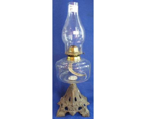 Single burner oil lamp with glass reservoir and cast metal base.