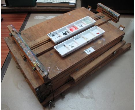Folding artist's easel with two ceramic pallets.