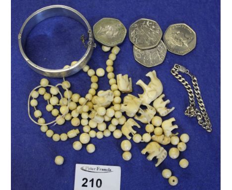 Bag containing silver engraved bangle, 50p pieces, various beads and carved elephant, and silver bracelet.