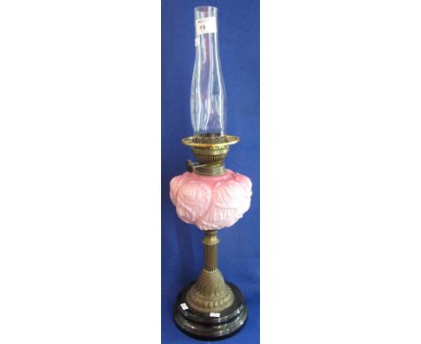 Brass double burner oil lamp (lacks burner) with pink glass reservoir, brass pedestal and ceramic base.