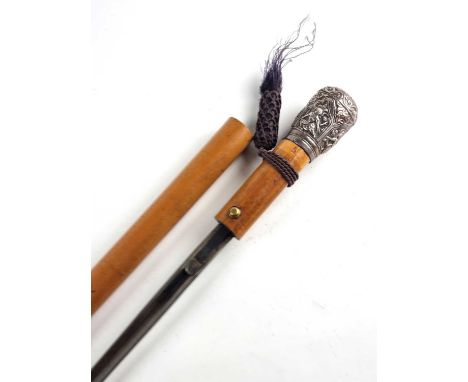 An early 20th-century gentleman's malacca walking cane, with a white metal, chased pommel decorated in the Indian style, the 