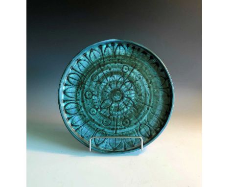 A Troika pottery plate with insciced floral and leaf decoration, embossed 'Troika St Ives' trident mark, diameter 23cm.