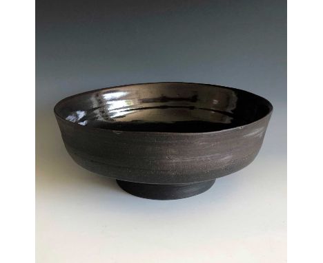 A large black clay Janet Leach bowl, the inside of the bowl is tenmoku glazed, diameter 26cm, height 10cm, impressed makers m