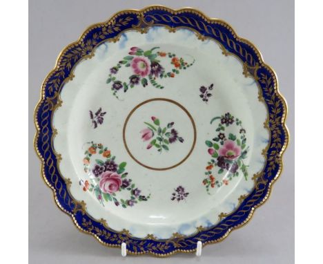 A late eighteenth century porcelain Worcester hand-painted flower pattern moulded plates with gilded rims,&nbsp; c. 1780-90. 