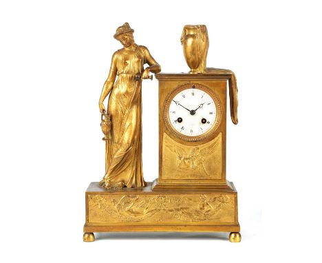 AN EARLY 19TH CENTURY FRENCH FIGURAL ORMOLU MANTEL CLOCK depicting a classical maiden standing beside a 3.25" enamel dial wit